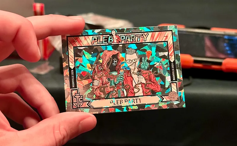 A hand holding a holographic Pleb Party trading card